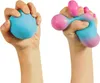Two hands squeezing a stress ball. The left hand holds a solid blue stress ball. The right hand holds a blue and pink stress ball that is being stretched and deformed. Voir les images du produit