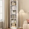 A tall white bookshelf filled with books and decorative items, next to a floor lamp and a sofa. Náhľad obrázku produktu