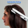 A woman is using a white hair straightener on her brown hair. Produktbild-Vorschau