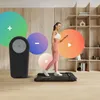 A woman is walking on a treadmill in a room, with colorful circles and icons overlaid on the image. Podgląd zdjęcia produktu
