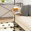 A laptop table with wheels is positioned next to a sofa in a living room setting. Podgląd zdjęcia produktu