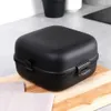 A black lunchbox on a wooden cutting board. Náhľad obrázku produktu