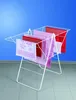A white metal drying rack with several towels and rugs draped over it, set against a blue background and on a tiled floor. Anteprima dell’immagine prodotto