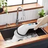 A hand is using an electric cleaning brush in a kitchen sink. Voir les images du produit