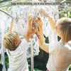 A child and an adult are hanging laundry on a drying rack. Produktbild-Vorschau