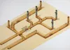 A diagram showing a plumbing system with pipes embedded in a sandy or concrete-like material. Náhľad obrázku produktu