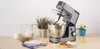 A kitchen mixer is set up on a wooden table with ingredients for baking. Podgląd zdjęcia produktu