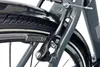 A close-up view of a bicycle's rear brake mechanism and tire. Produktbild-Vorschau