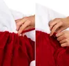 Close-up of hands demonstrating how to tie a drawstring on a red velvet Christmas sack with white trim. Produktbild-Vorschau