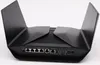 The back view of a black Netgear Nighthawk Rax120 wireless router with its antennas extended. Podgląd zdjęcia produktu