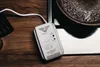 A gas and carbon monoxide detector is placed on a wooden surface next to a stovetop with a pot of boiling water. Podgląd zdjęcia produktu