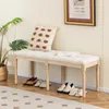 A bench in an entryway with shoes underneath and a plant and picture on the wall. Podgląd zdjęcia produktu