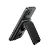 A black smartphone is propped up by a black accessory on a white background. Náhled obrázku produktu