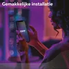 A person is holding a smartphone with the Calex app open, with colorful lights in the background. Produktbild-Vorschau