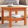 A wooden side table with a cup and saucer on top and books on the lower shelf, placed on a carpet next to a sofa. Náhled obrázku produktu