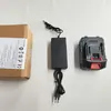 A cardboard box, a battery charger, and a battery are laid out on a white surface. Produktbild-Vorschau