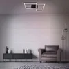 A modern living room with a brick wall, a black media console, a brown armchair, and floor lamps. Produktbild-Vorschau