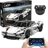 A collage of images showing a white sportscar building block set, its packaging, a remote control, and a smartphone displaying a control interface. Produktbild-Vorschau