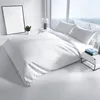 A neatly made bed with white bedding in a bright, modern room with large windows. Produktbild-Vorschau