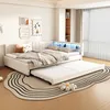 A bedroom scene featuring a beige upholstered sofa bed with a trundle pulled out, decorated with pillows and blankets. The headboard has built-in LED lighting. Podgląd zdjęcia produktu