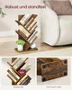 A wooden tree-shaped bookshelf filled with books, placed in a living room setting next to a chair. Produktbild-Vorschau