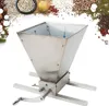A stainless steel grain mill with a crank handle, set against a background of various grains and dried fruits. Podgląd zdjęcia produktu
