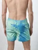 Minzgrüne und blaue Schwimmshorts mit Spritzmuster, von hinten von einem Mann getragen, mit Wassertropfen Náhľad obrázku produktu
