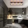 A modern kitchen with dark cabinets, a stainless steel stove, and a black ceiling light fixture. Voir les images du produit