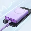 A purple power bank is charging a black smartphone. Podgląd zdjęcia produktu