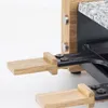 Close-up of a raclette grill with wooden handles and a granite stone top. Produktbild-Vorschau