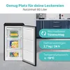 A small black freezer with its door open, showing its interior and shelves. The background shows a kitchen counter and cabinets. Text overlays highlight product features. Produktbild-Vorschau