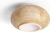 A close-up view of a round ceiling light made of woven bamboo with a white diffuser. Produktbild-Vorschau