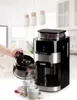 A coffee maker is in the process of pouring coffee into two mugs, with coffee beans in the grinder compartment. Podgląd zdjęcia produktu