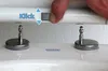 A hand is shown pressing a button on a toilet seat hinge mechanism. Produktbild-Vorschau