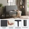 A grey fabric bench with a throw blanket and a book on it, placed in a room with a coat rack, plant, and doorway in the background. Four smaller inset images below highlight the fabric texture, cushion comfort, solid wood legs, and protective feet. Podgląd zdjęcia produktu