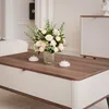 A close-up of a coffee table with a floral arrangement and candles. Voir les images du produit
