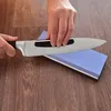 A person is sharpening a knife on a sharpening stone. Produktbild-Vorschau
