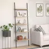 A ladder shelf filled with decorative items and books, placed next to a sofa in a living room. Produktbild-Vorschau