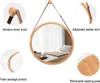 A round mirror with a wooden frame and a leather strap hanging from a hook, with close-up insets highlighting its features. Produktbild-Vorschau