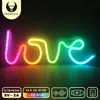 A neon LED sign spelling out 'love' in multiple colors, displayed against a dark background with promotional text and icons at the bottom. Anteprima dell’immagine prodotto