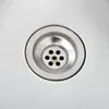 A close-up view of a stainless steel sink drain. Voir les images du produit