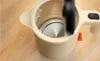 A close-up view of the interior of a beige electric kettle, showing the heating element and the inside of the lid. Produktbild-Vorschau