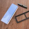 A sharpening stone with a pad and knife holder on a wooden surface. Produktbild-Vorschau