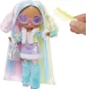 A fashion doll with colorful hair, wearing a stylish outfit and accessories, with a comb held by a hand in the background. Anteprima dell’immagine prodotto