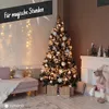 A decorated Christmas tree in a cozy living room setting with a sofa and fireplace. Náhľad obrázku produktu