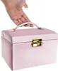 A hand is holding the handle of a pink jewelry box. Náhled obrázku produktu