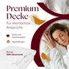 A woman sleeping peacefully in bed, with a folded duvet and marketing text about a premium blanket. Voir les images du produit