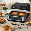 A kitchen scene with a multi-compartment air fryer in use, surrounded by various prepared foods. Produktbild-Vorschau