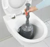 A hand is using a plunger to clear a toilet. Produktbild-Vorschau