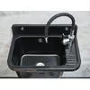 A black sink with a flexible chrome faucet mounted on a gray tiled wall. Produktbild-Vorschau